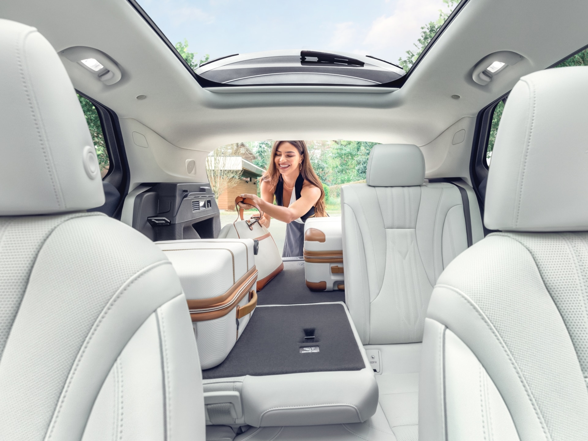 Interior View of a 2025 Buick Envision 5 Passenger SUV with a Person Loading Luggage Into the Trunk